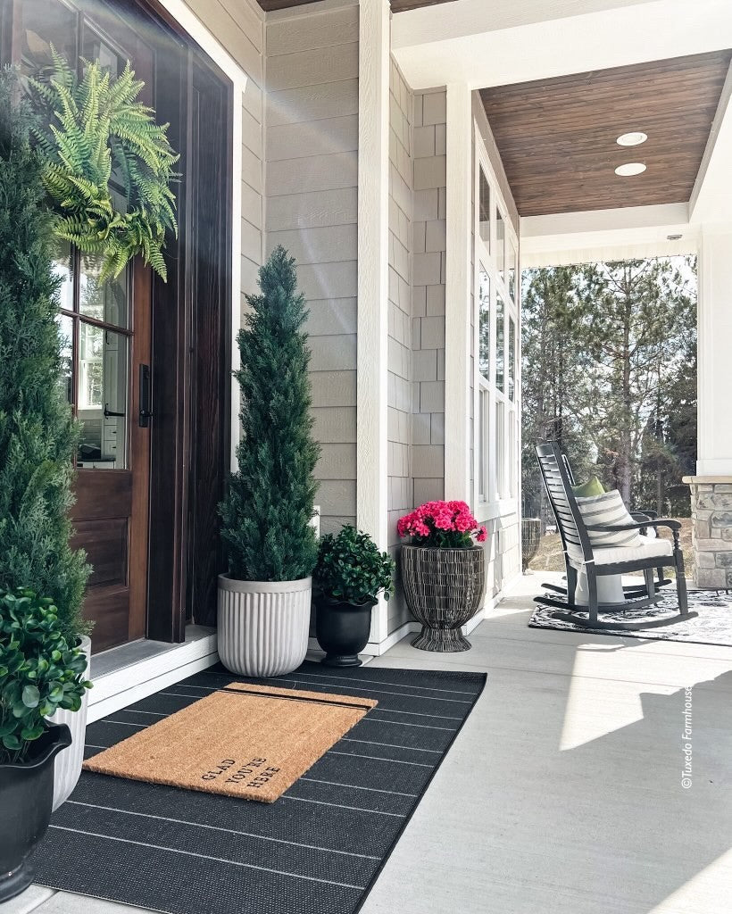 a porch with a chair and a rug
