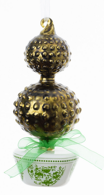 a gold and green ball shaped object with a green bow