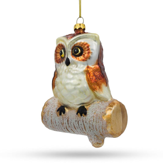 an owl ornament on a tree branch