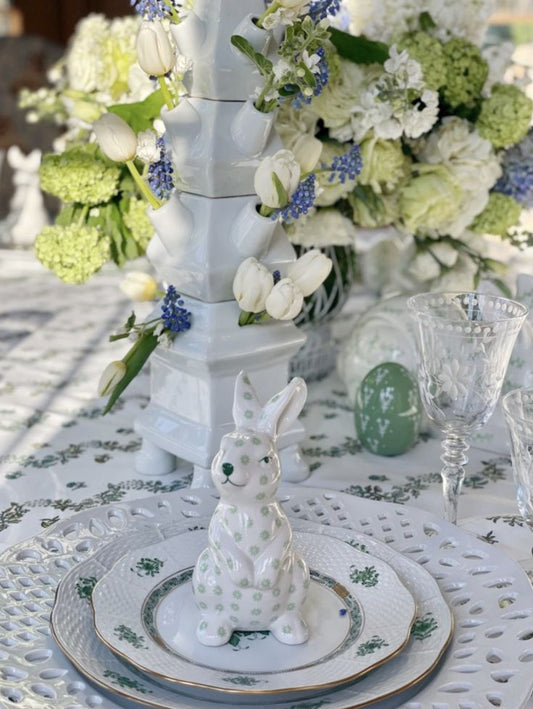 a white and green bunny on a table with flowers