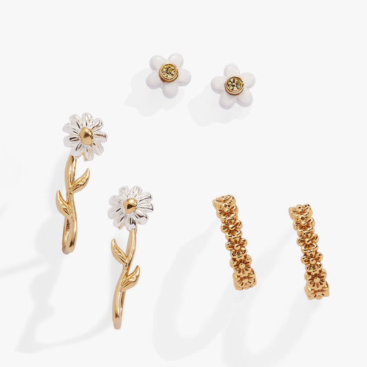 a group of gold and white earrings