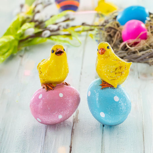 two yellow birds on eggs