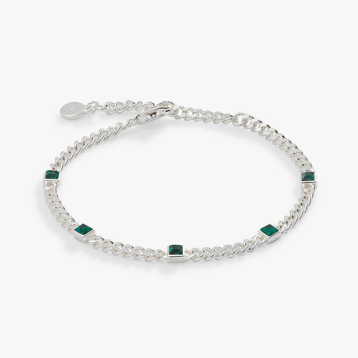 a silver bracelet with green stones