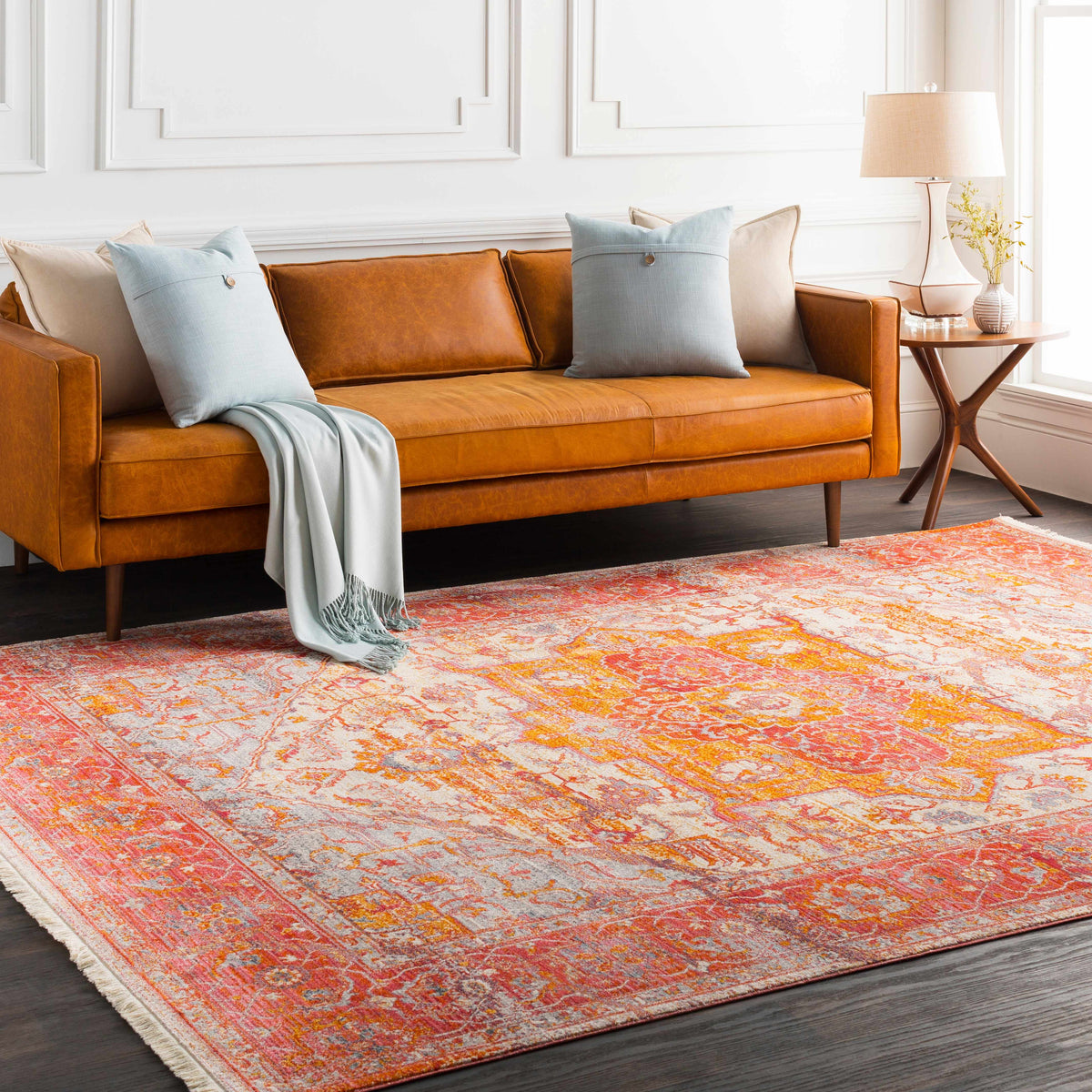 a couch with pillows and a rug in a room