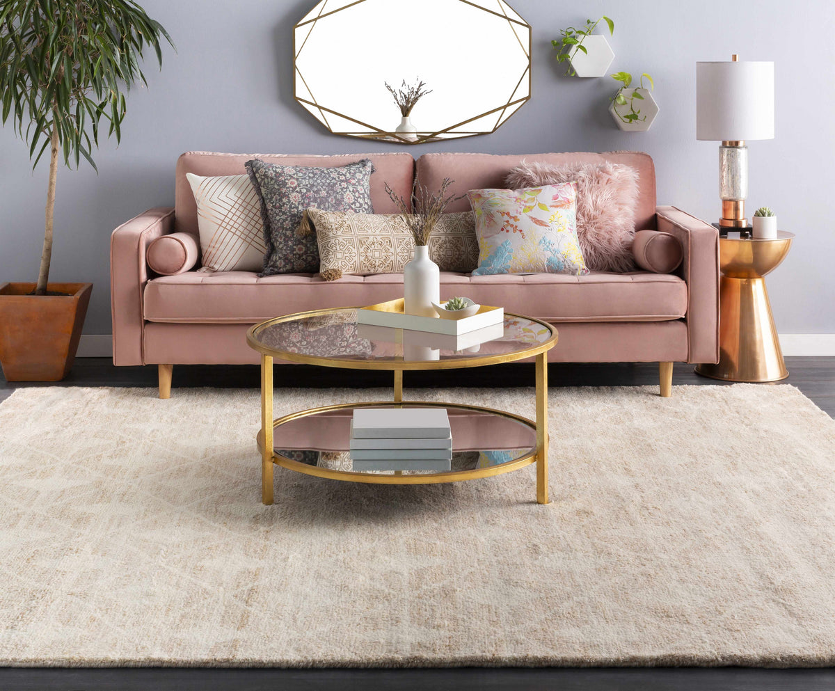 a living room with a pink couch and a round coffee table