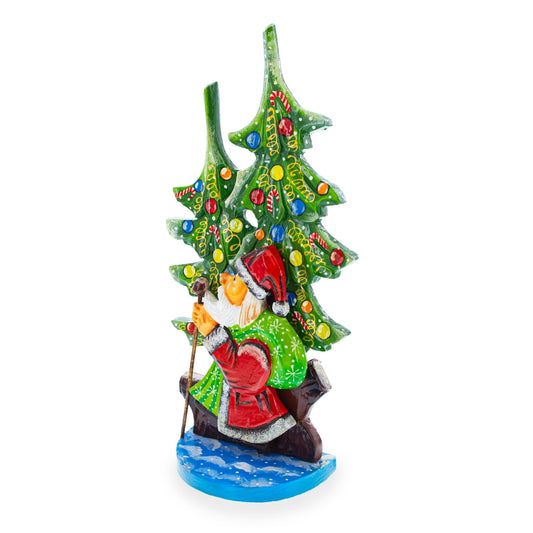 a statue of a santa claus holding a cane and a christmas tree