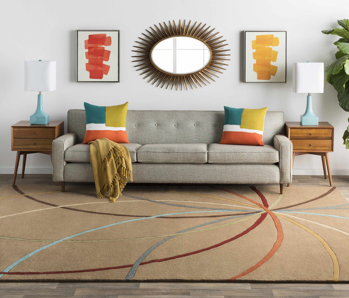 a couch with pillows and a mirror above a rug