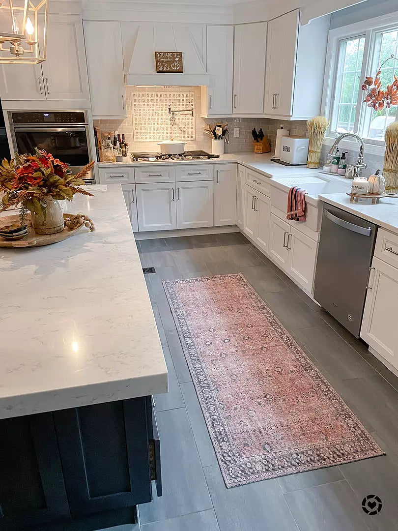 a kitchen with a rug and a flower vase