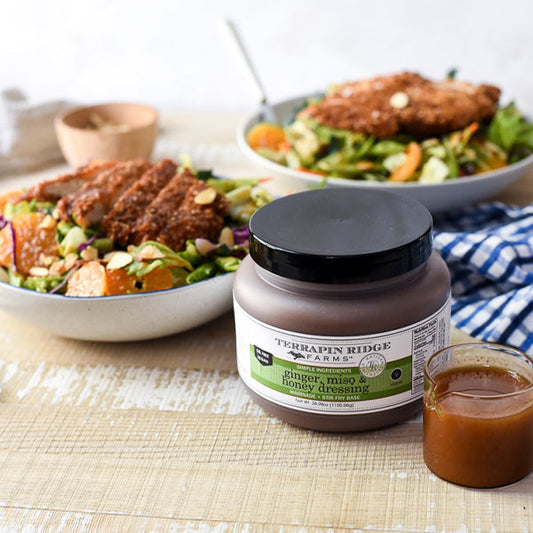 a bowl of salad and a jar of sauce