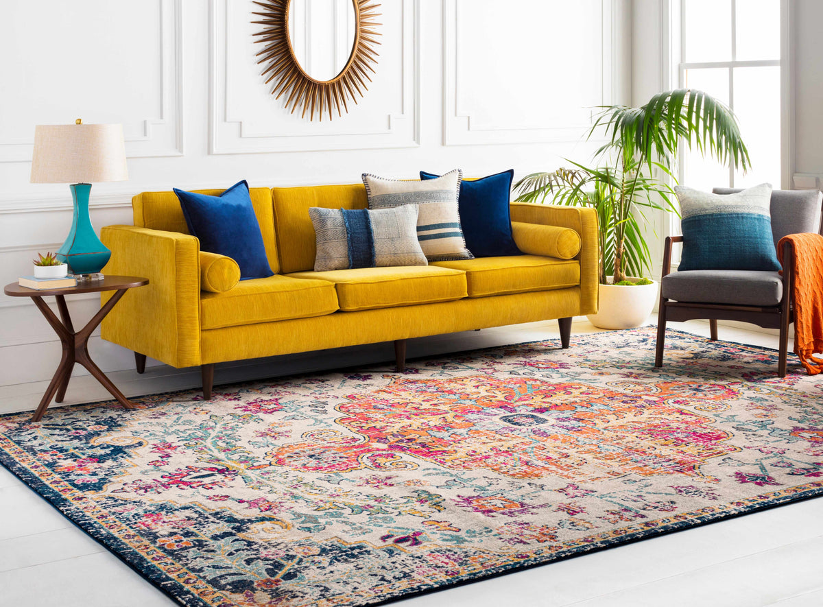 a yellow couch in a room with a colorful rug and a mirror