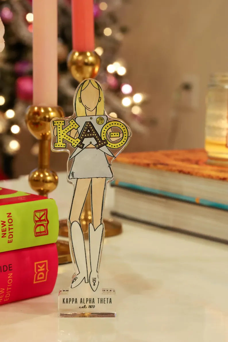 a paper cutout of a woman in a dress next to books