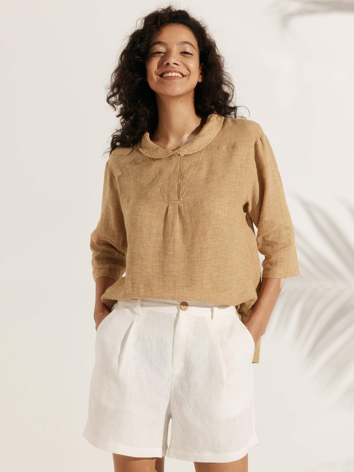 a woman with brown hair and white pants