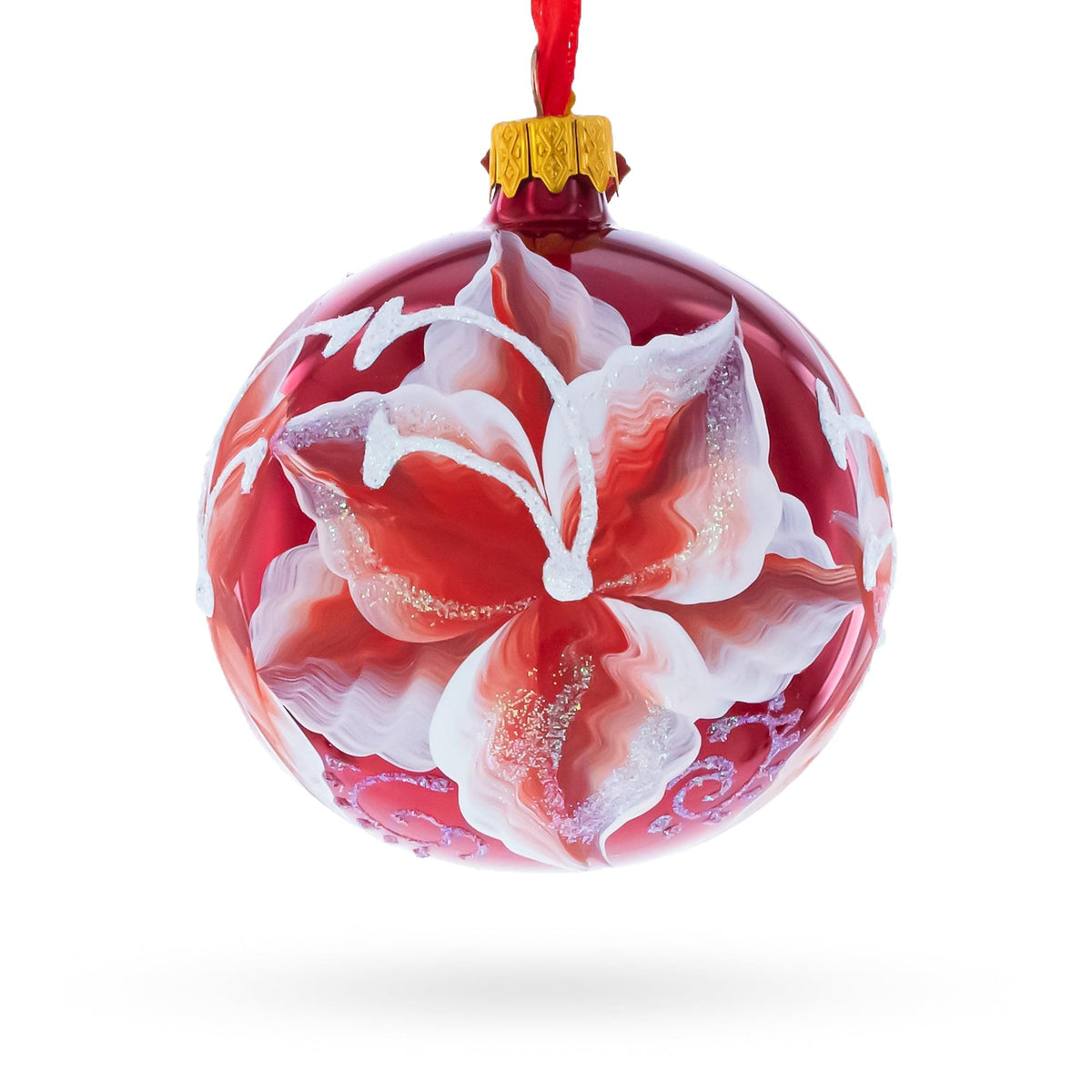 a red and white ornament with a flower painted on it