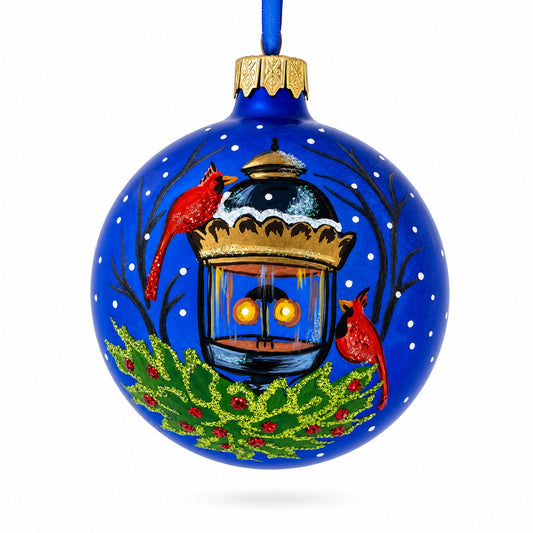 a blue christmas ornament with a painting of birds and a bird on it