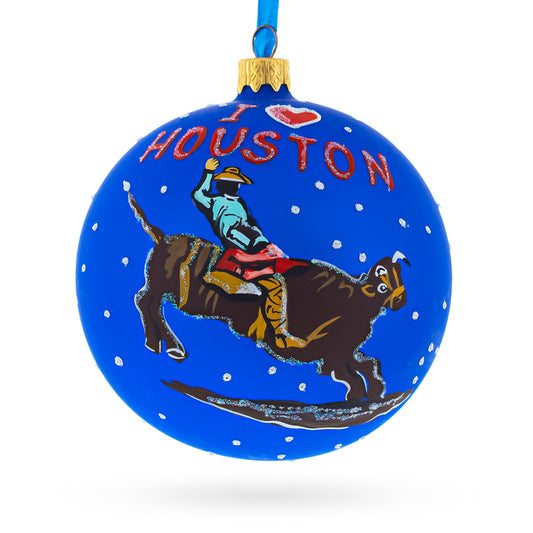 a blue christmas ornament with a cowboy riding a bull