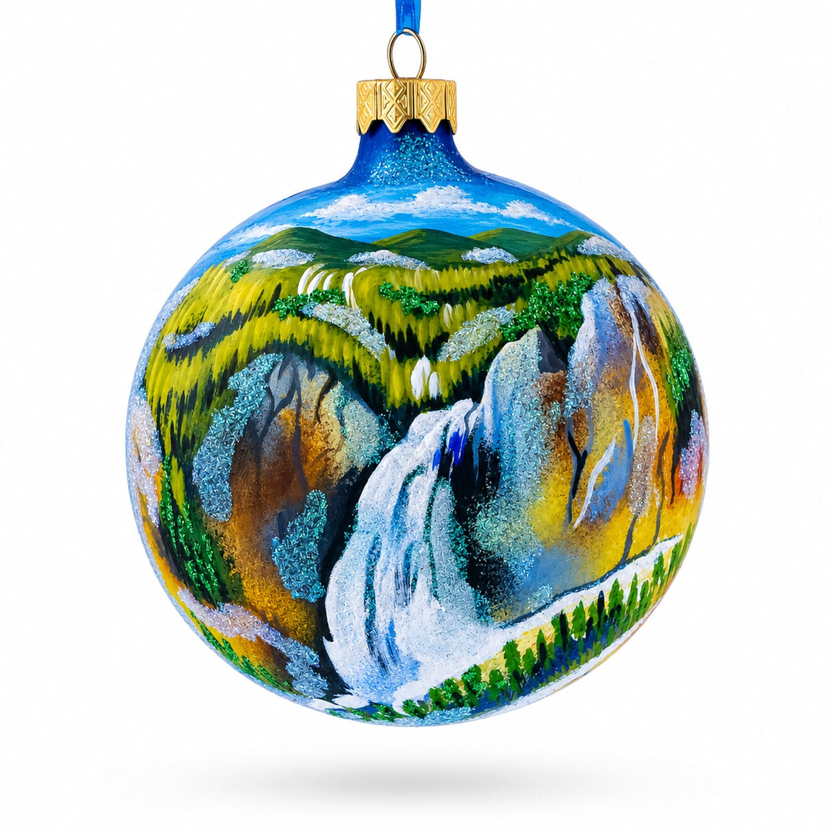 a blue and yellow ornament with a waterfall painted on it