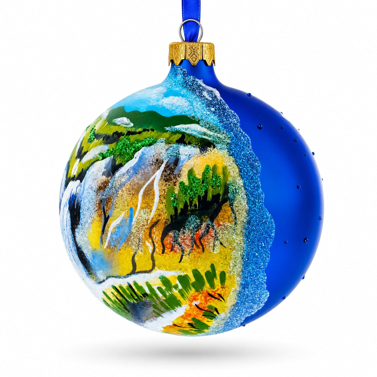 a blue christmas ornament with a painting on it
