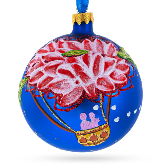 a blue christmas ornament with a painting of a hot air balloon