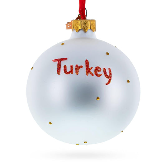 a white and gold ornament with red text