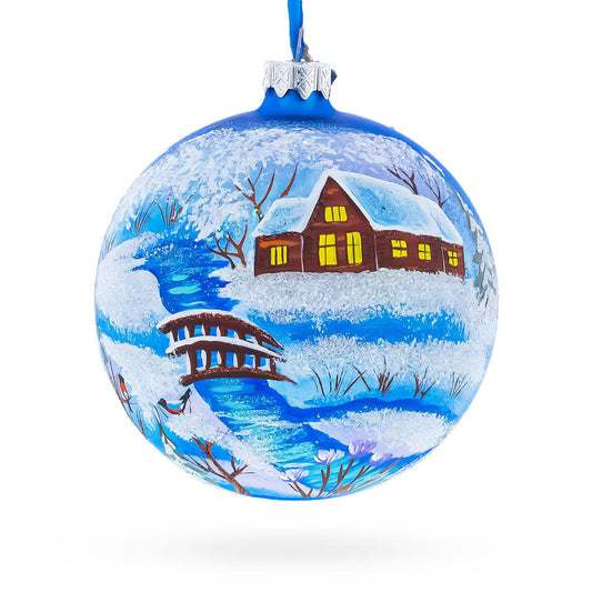 a blue christmas ornament with a house and a river