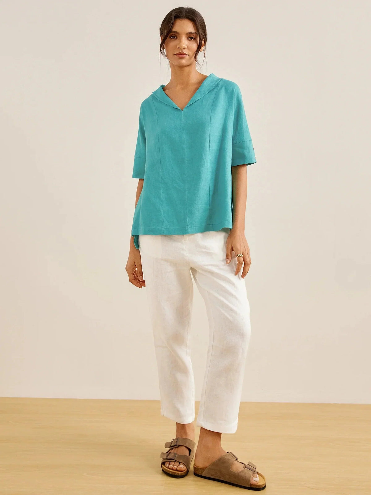 a woman in a blue shirt and white pants