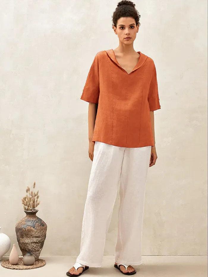 a woman in a brown shirt and white pants
