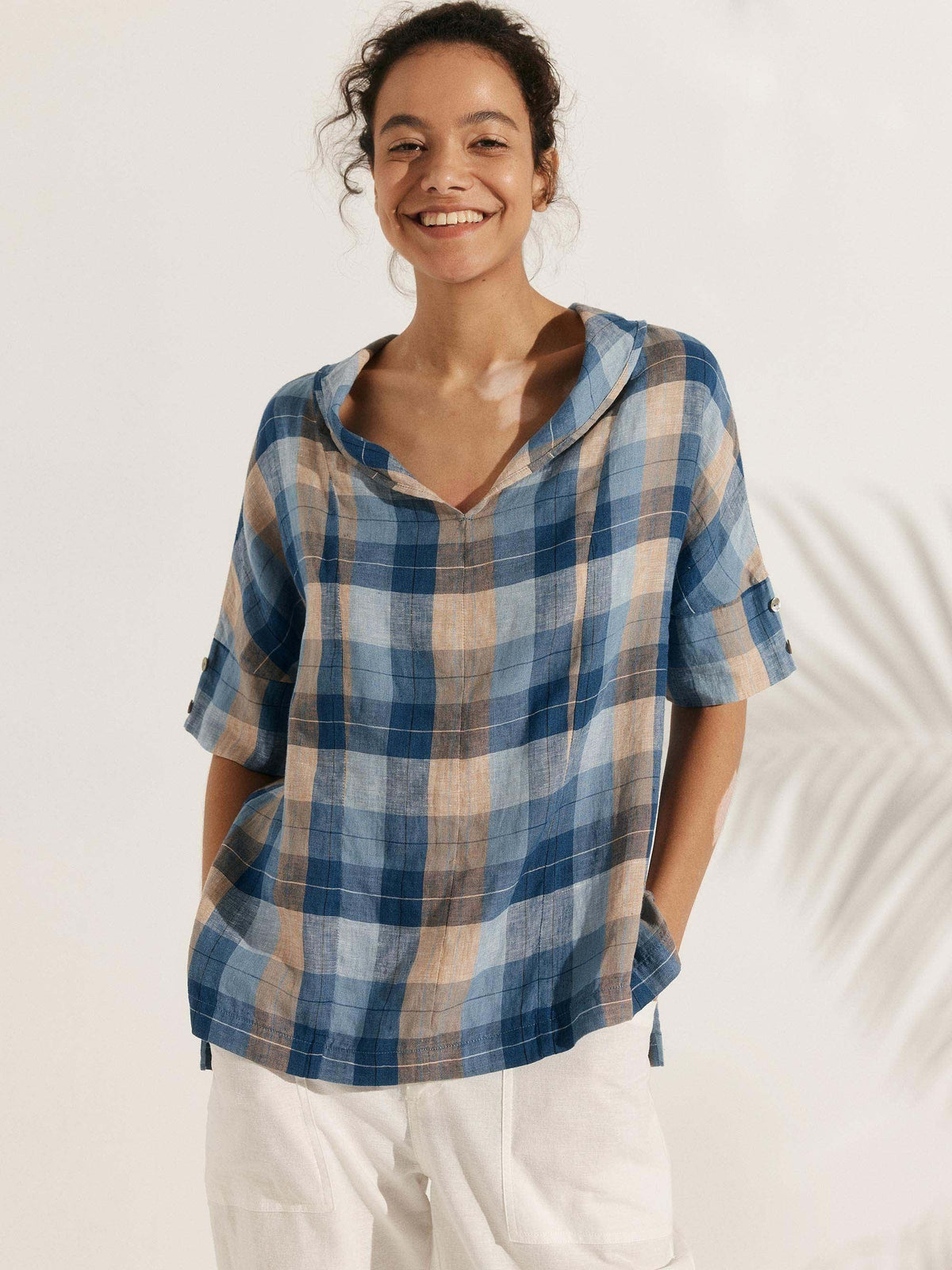 a woman smiling with her hands in her pockets