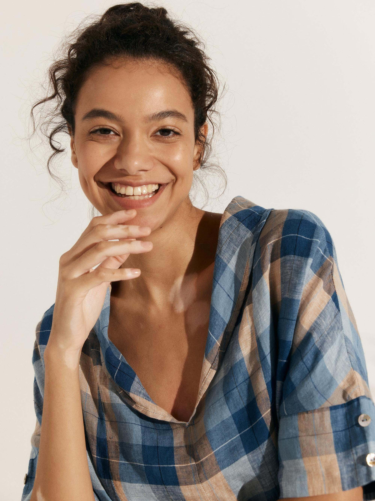a woman smiling with her hand on her chin