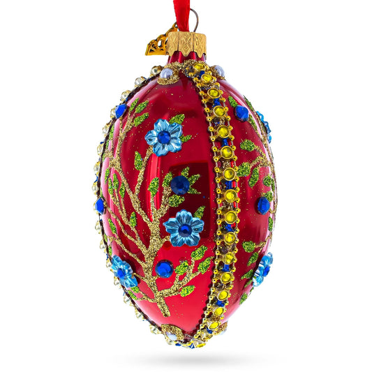 a red decorated egg with blue flowers and gems