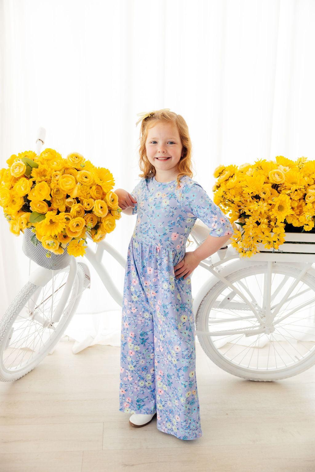 a girl standing next to a bicycle with flowers