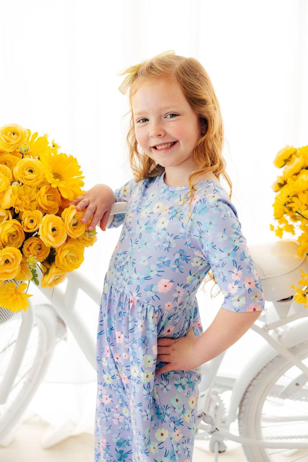 a girl standing next to a bicycle with flowers