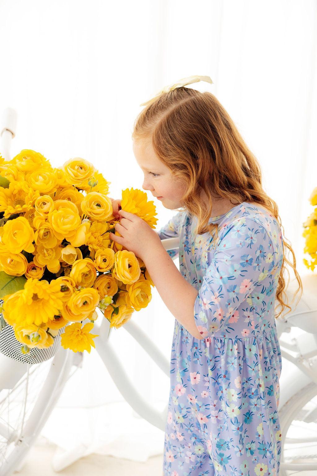 a girl looking at a flower