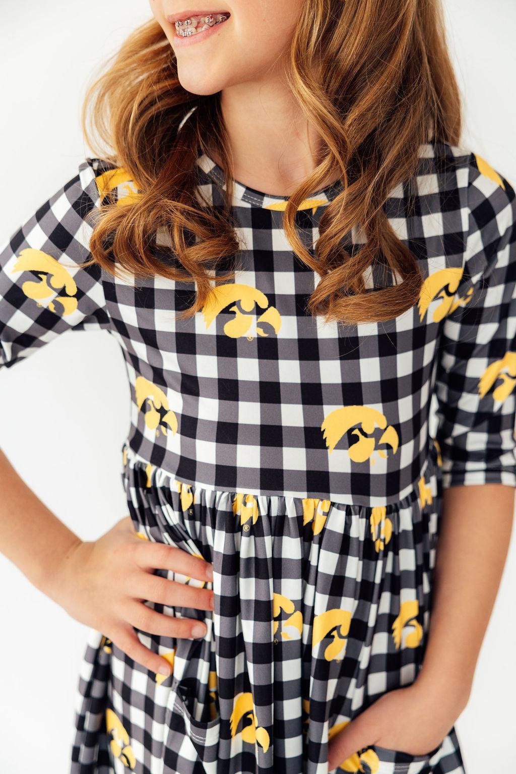 a girl wearing a checkered dress
