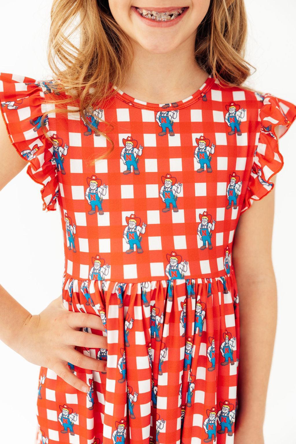 a girl wearing a red and white checkered dress
