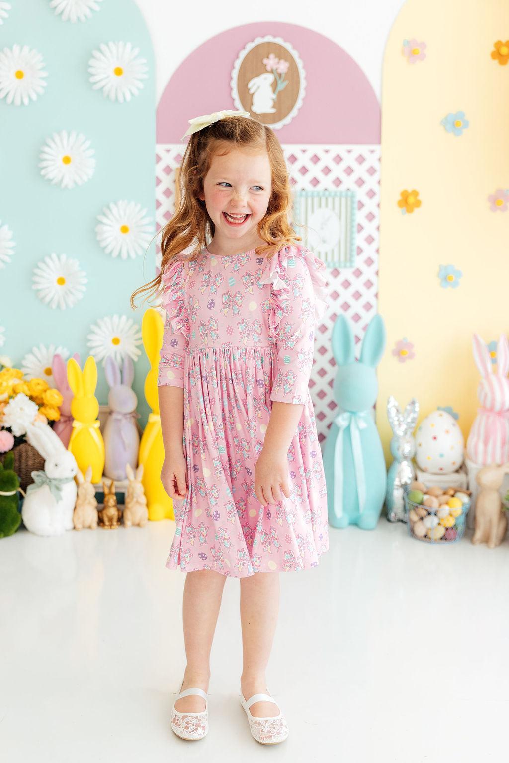 a girl smiling in a pink dress