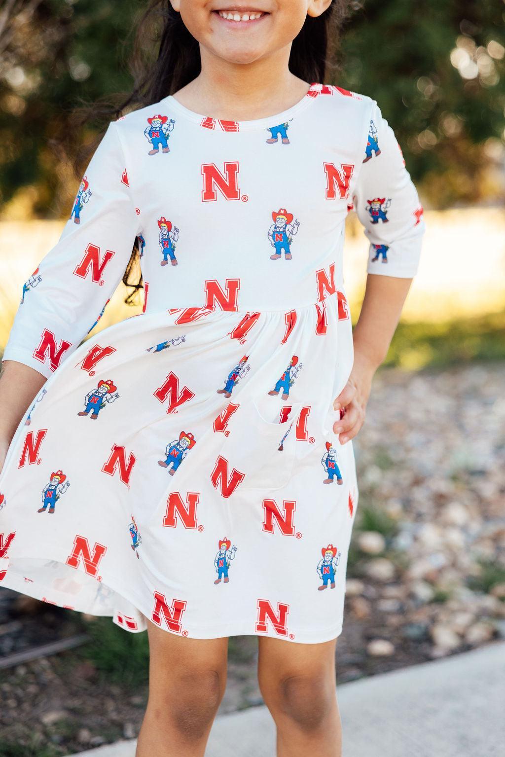 a woman in a dress with red and white letters on it