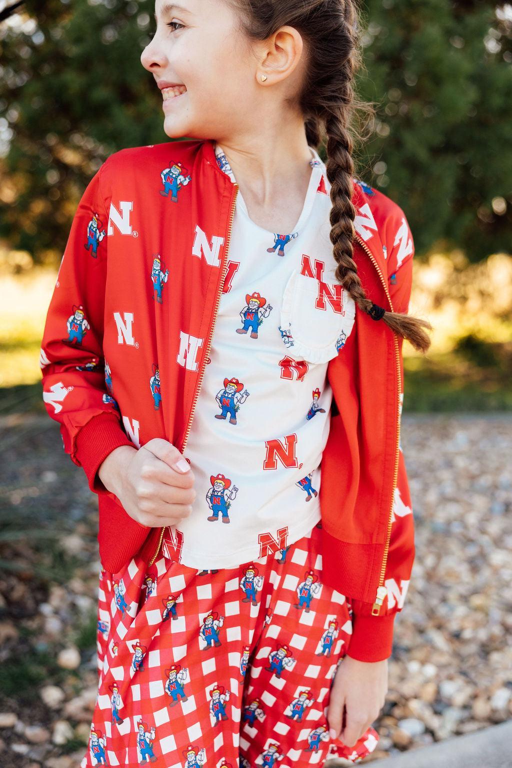 a girl in a red jacket and pajamas