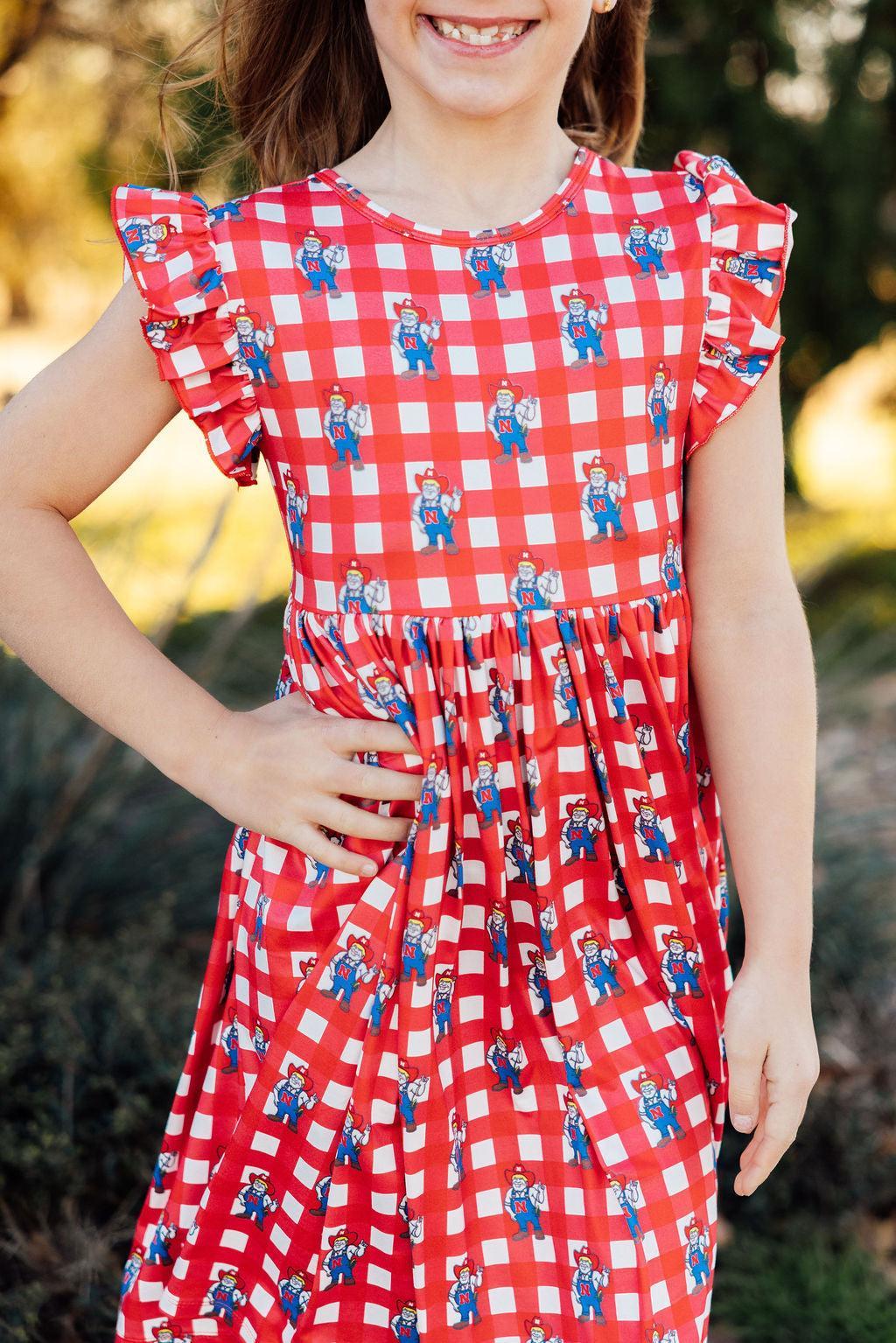 a girl wearing a red and white checkered dress