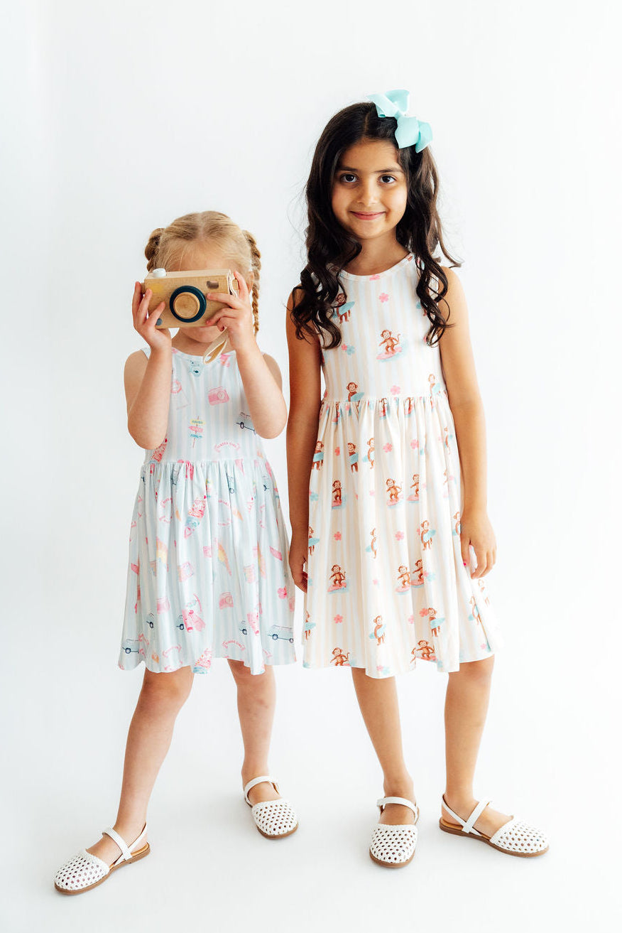 two girls wearing dresses and holding a camera