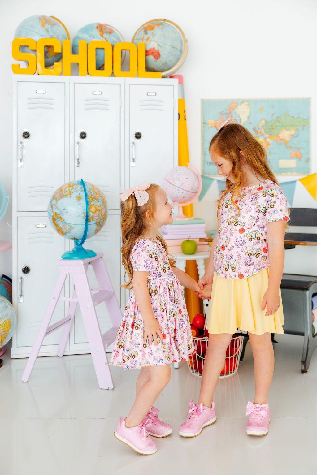 two girls holding hands in a classroom