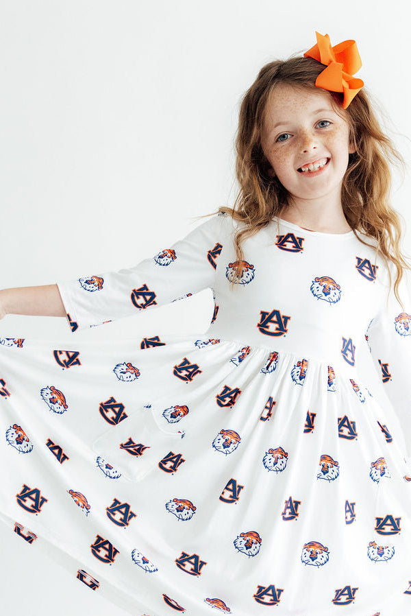 a girl wearing a dress with orange hair clip