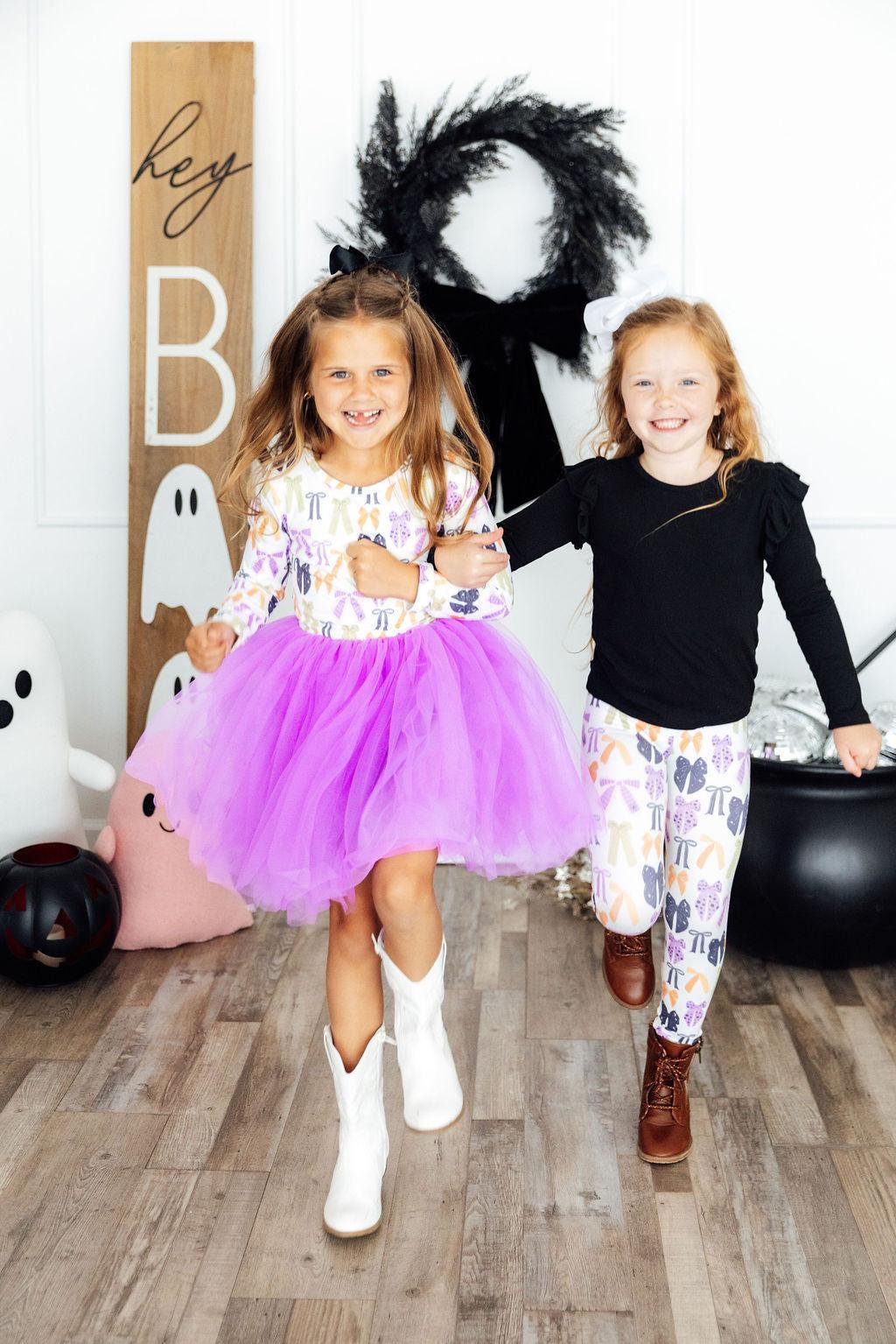 two girls running in front of a black and white ghost wall