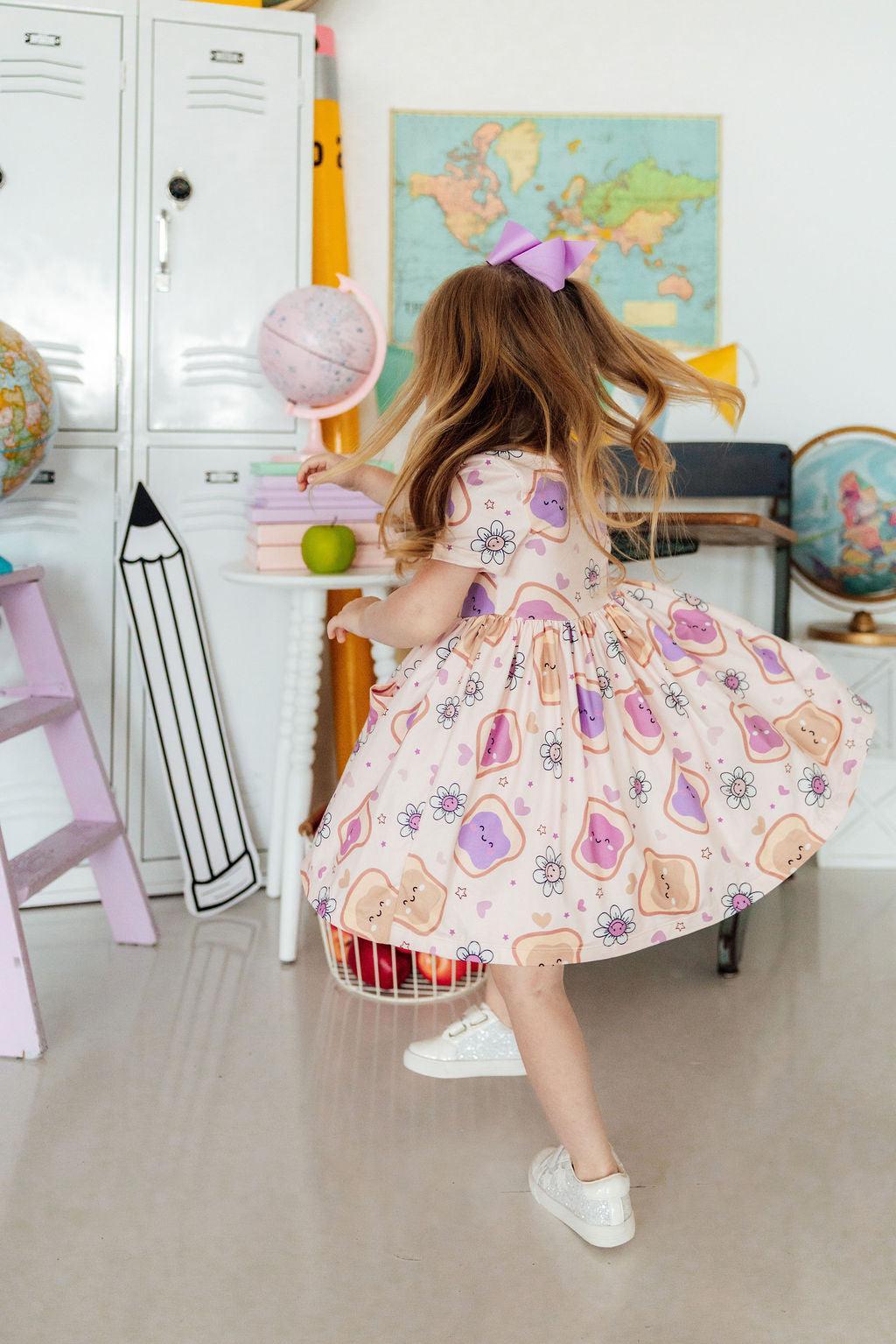 a girl in a dress with a purple bow in her hair