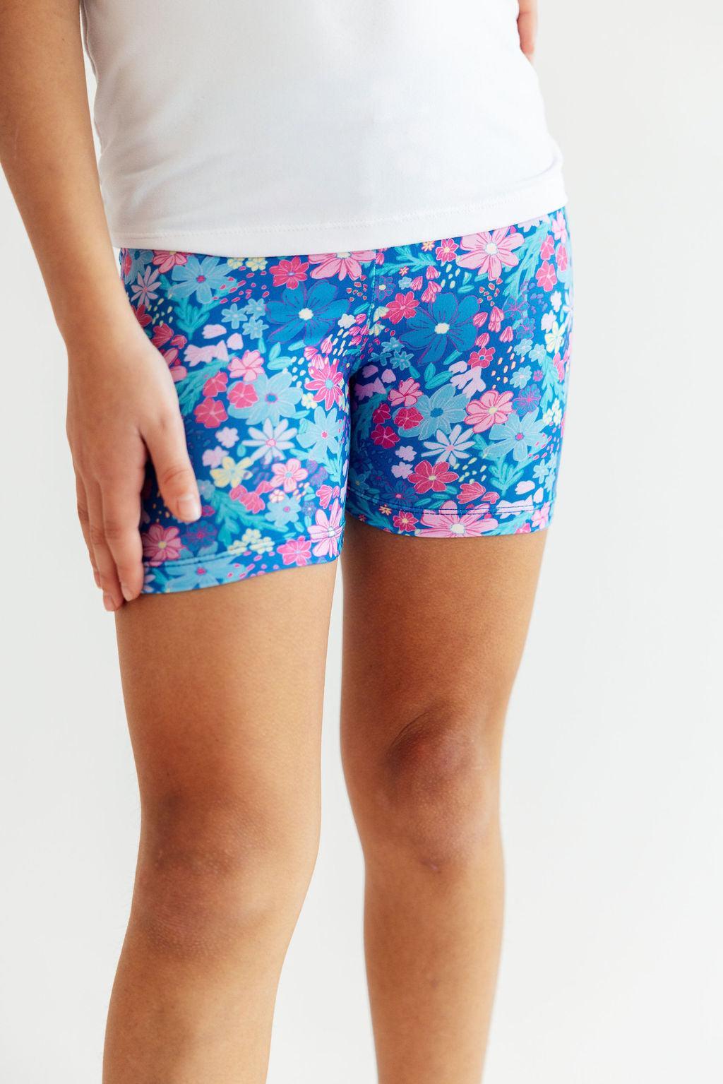 a person wearing shorts with flowers on them