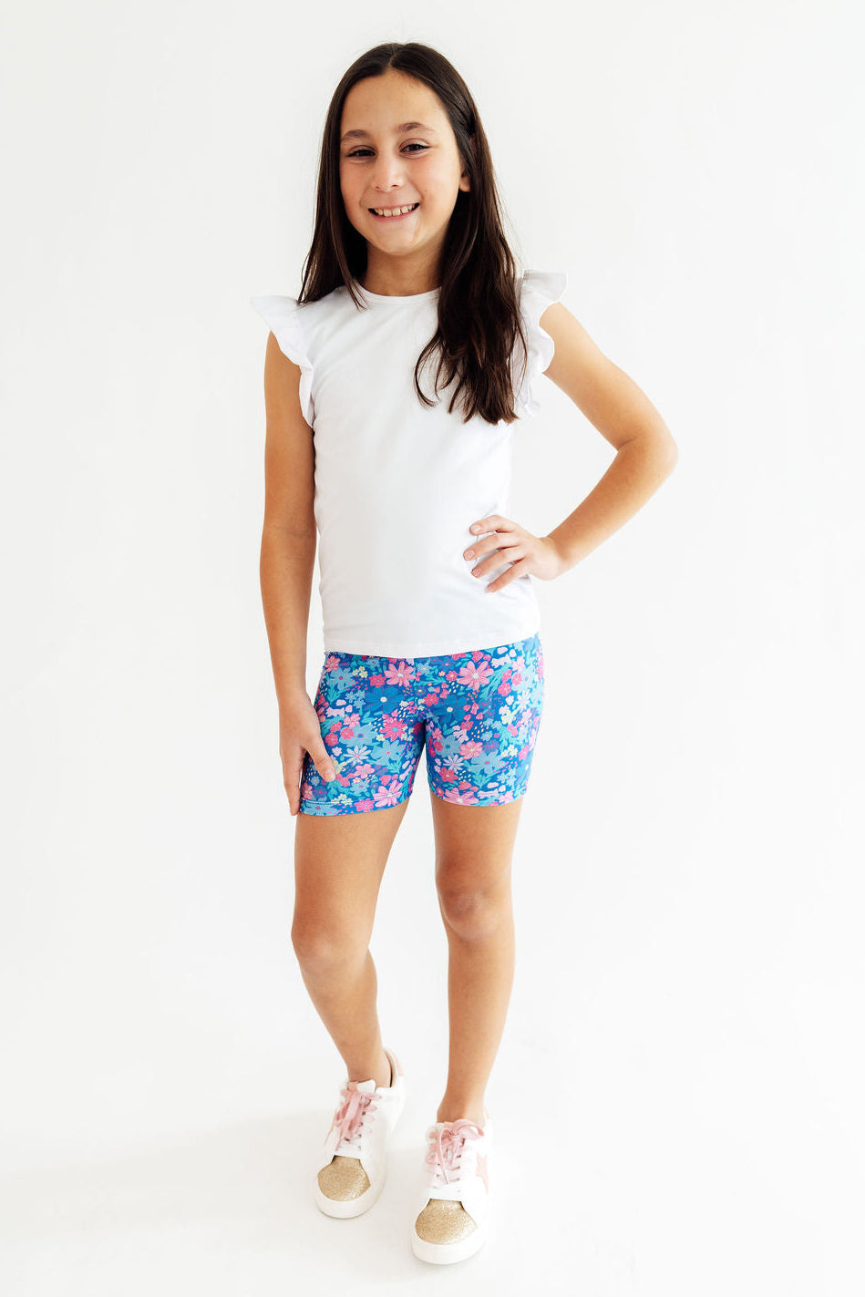 a girl in a white shirt and blue shorts