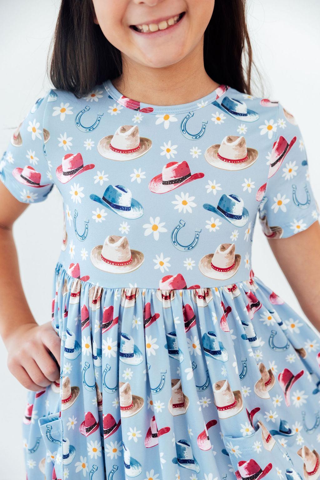 a girl wearing a dress with hats on it