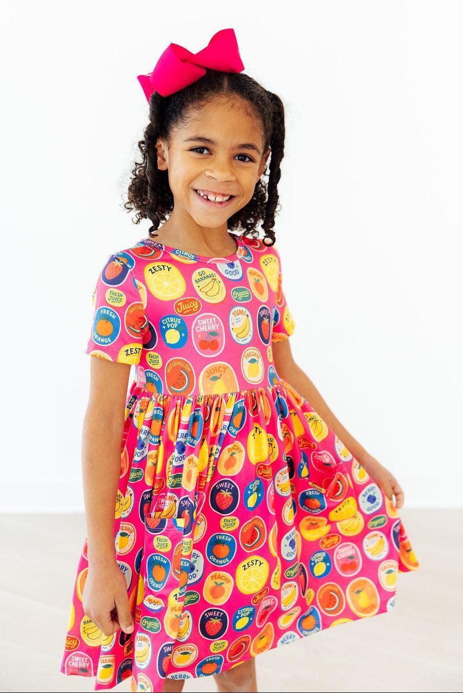 a girl smiling in a pink dress
