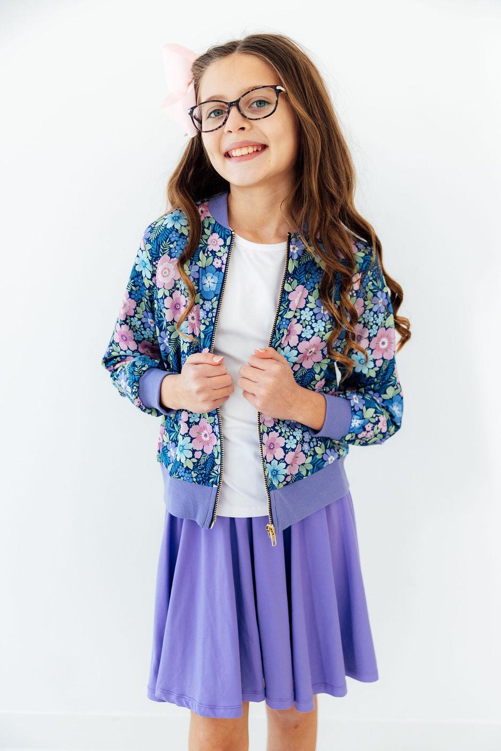 a girl wearing glasses and a floral jacket