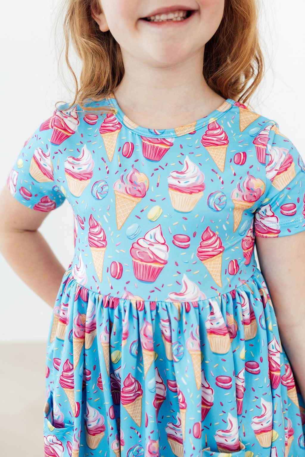a girl wearing a dress with ice cream on it