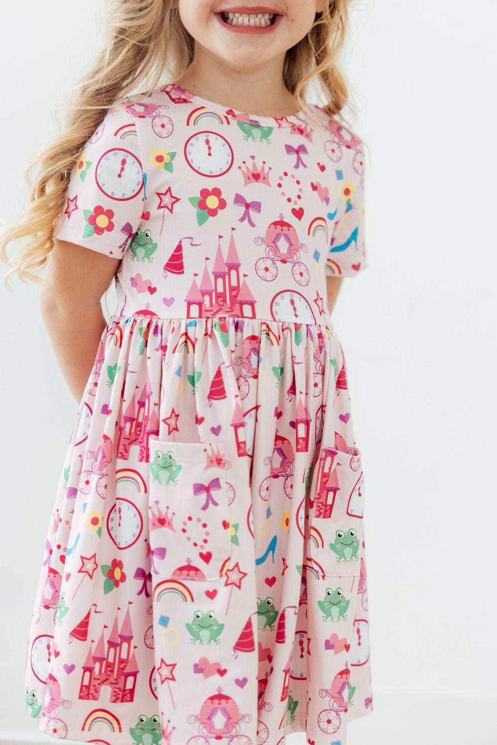 a girl wearing a pink dress with a cartoon print